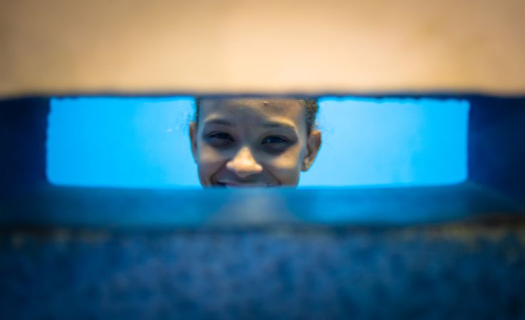 Rio de Janeiro, Brazil - February 13 2014: Cheerful kid looking at wall slit