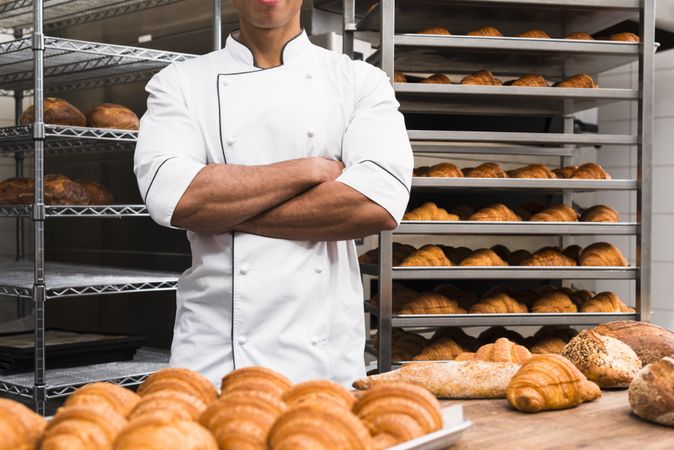 Midsection of male baker with his arms crossed standing bakery