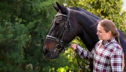 Woman in plaid shirt with a horse