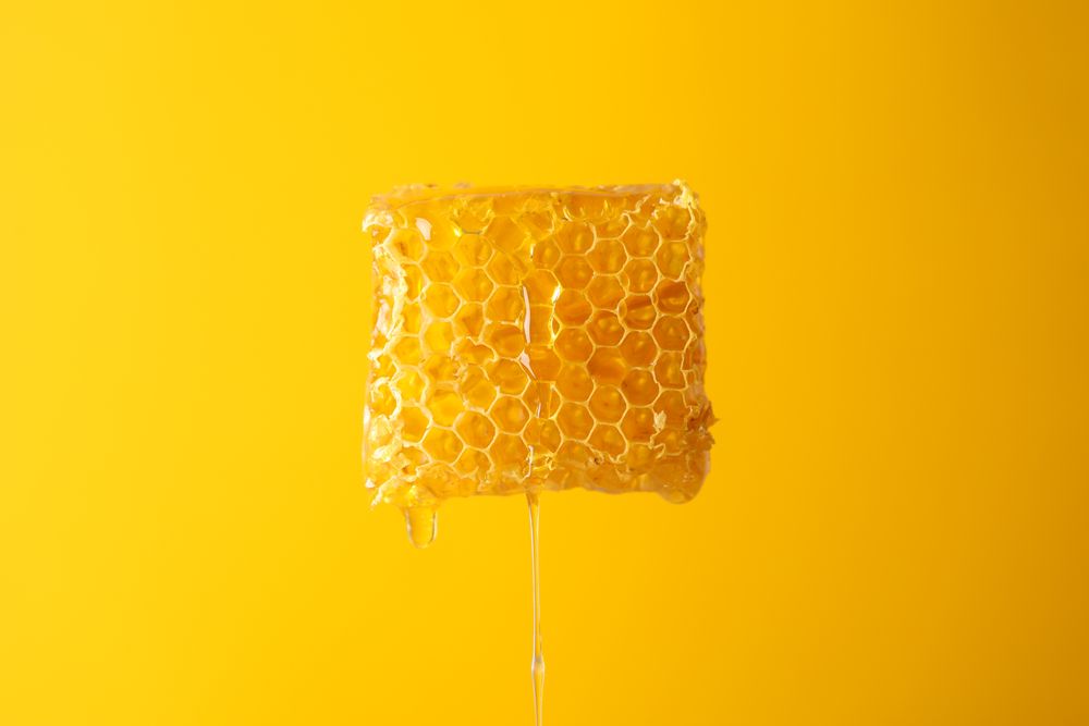 Honeycomb against yellow background, copy space