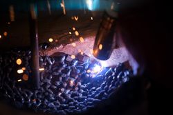 Welder joining metal in plaster mold