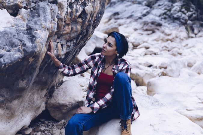 Positive woman sitting on stone