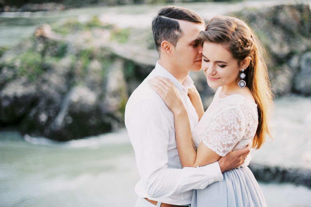 Man kissing woman in wedding dress