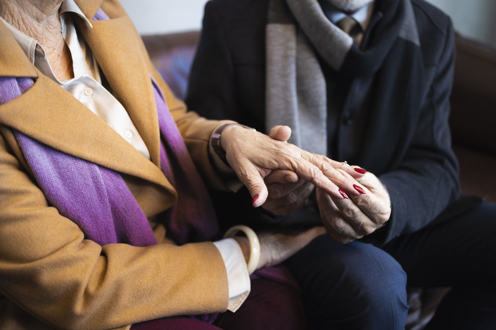 Mature couple with man putting ring on his new fiancé