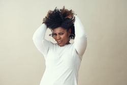 Portrait of playful Black woman running her hands through her hair