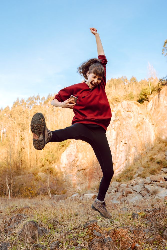 Young woman with smartphone dancing