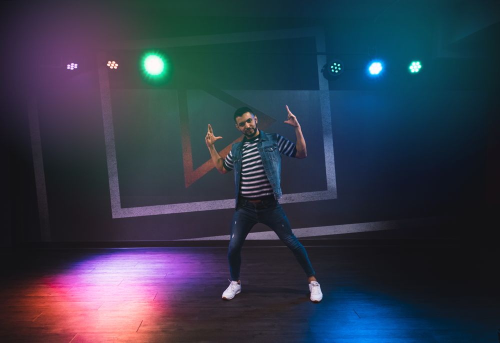 Modern man dancing actively in spotlight