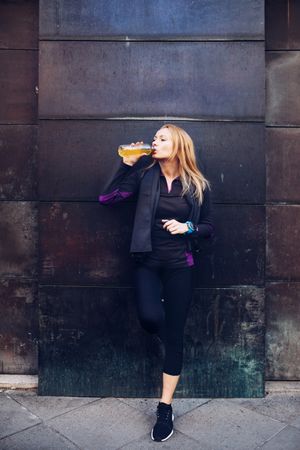 Woman drinking isotonic drink while resting