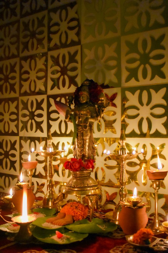Buddha figurine surrounded by diyas and flowers