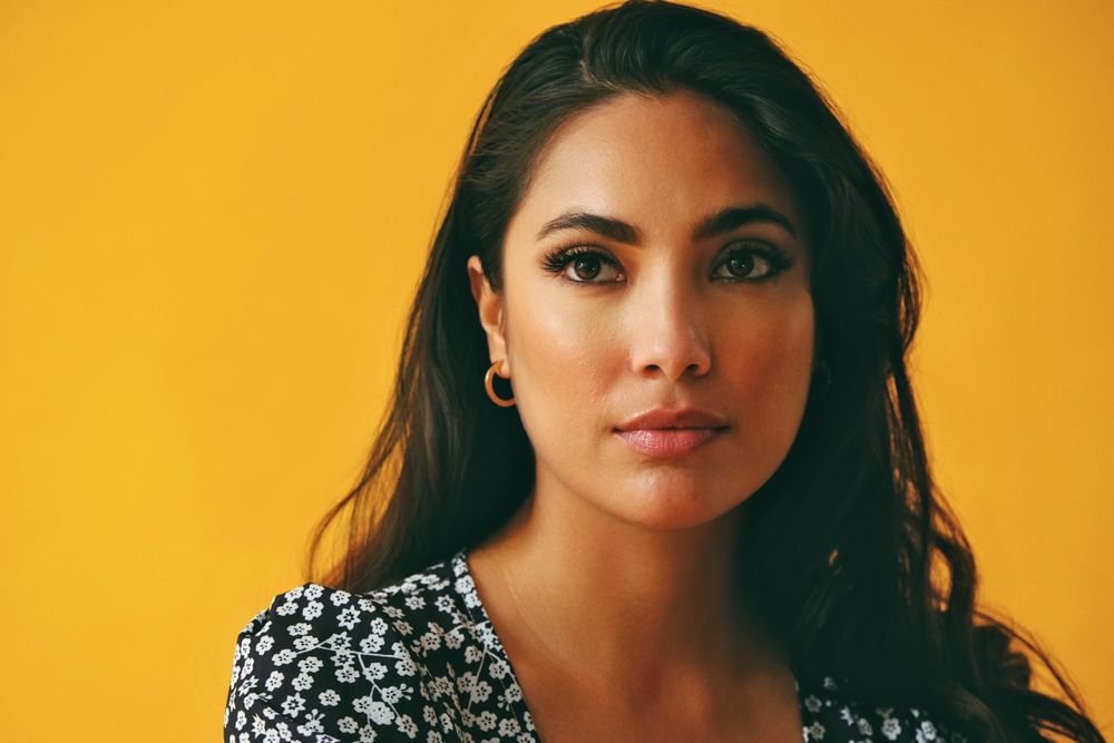 Hispanic woman wearing dress in yellow room