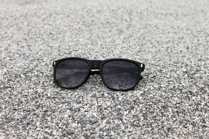 Sunglasses sitting on grey sand