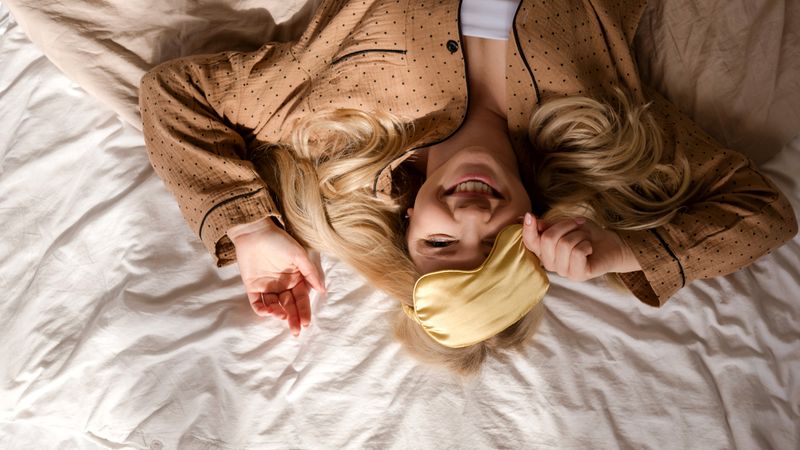 Overhead view of woman lying on bed