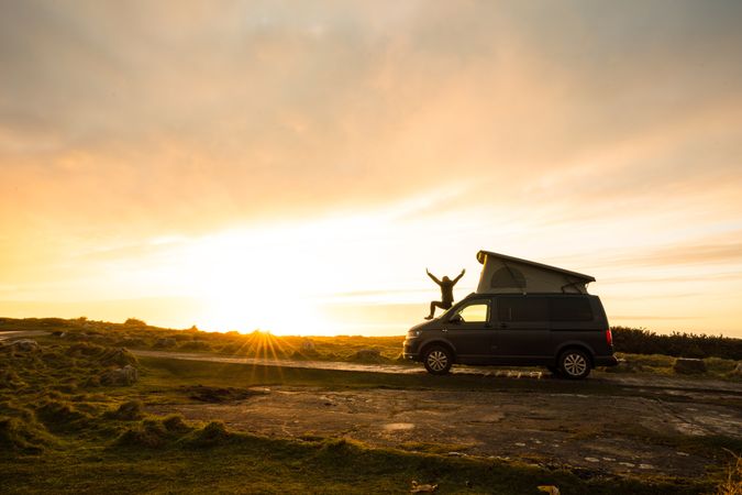 Man with opening hands standing on caravan