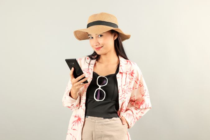 Happy Asian Traveler Woman Joy Relaxing on Summer Vacation Holding Black Smartphone