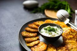 Traditional Ukrainian dish deruny arranged on plate with dipping sauce