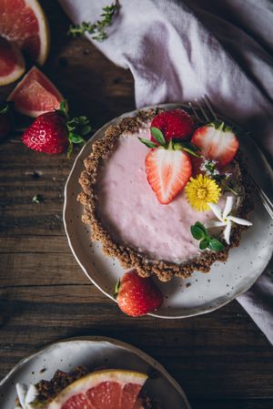 Strawberry and citrus cake served on wooden table
