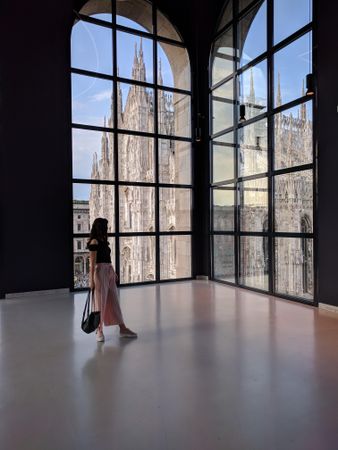 Woman holding purse looking at window in Museo del Novecento In Milano, Italy