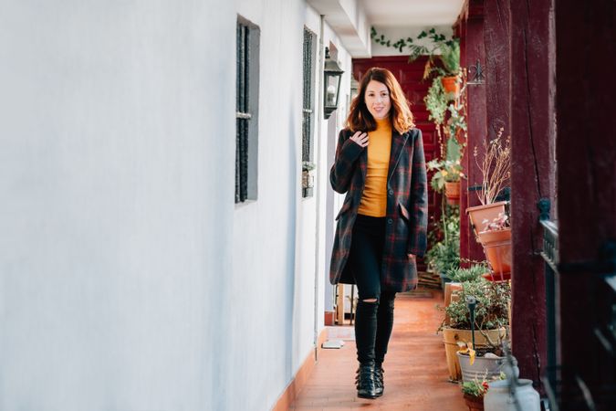 Smiling woman going on corridor in house