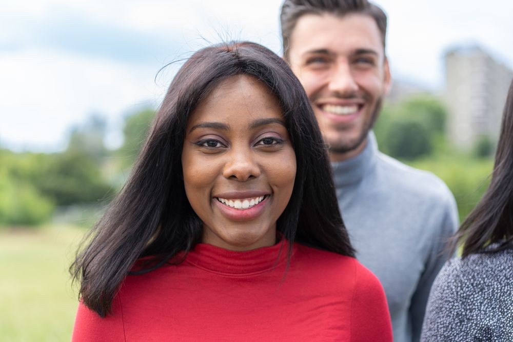 Smiling Black woman with friends outdoors