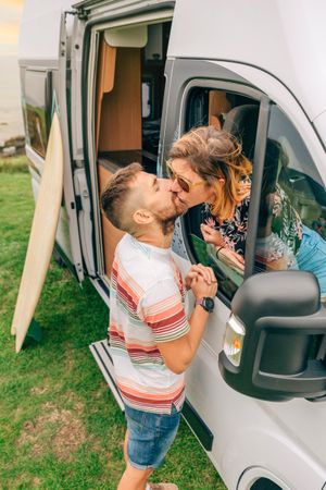 Vertical shot of male and female kissing out motorhome window