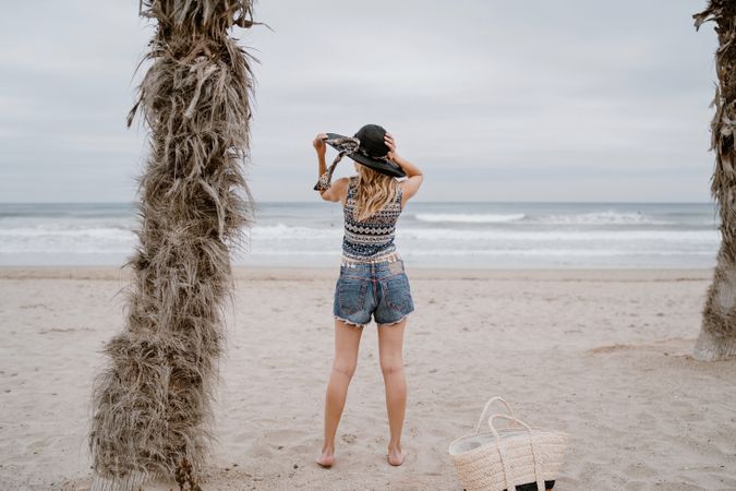Young female relaxing on beach with hat