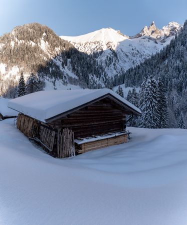 Winter scenery with snow-covered hut and mountain peaks in Bavaria, Germany