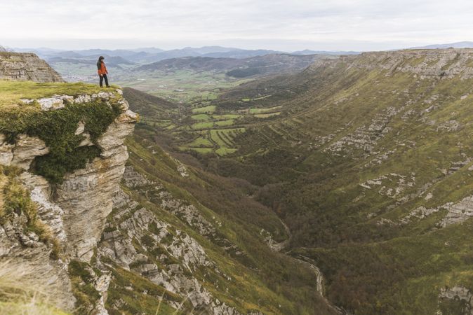 Man standing on cliff near valley