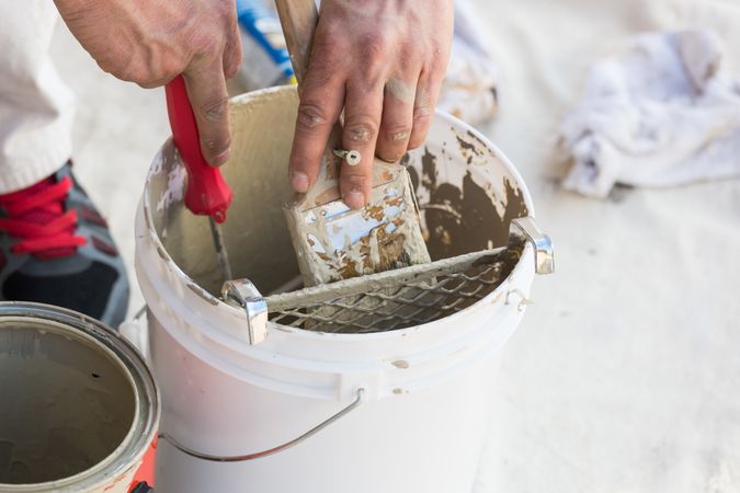 Professional Painter Loading Paint Onto Brush From Bucket