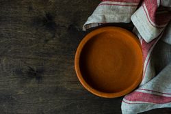 Empty terracotta bowl on wooden table