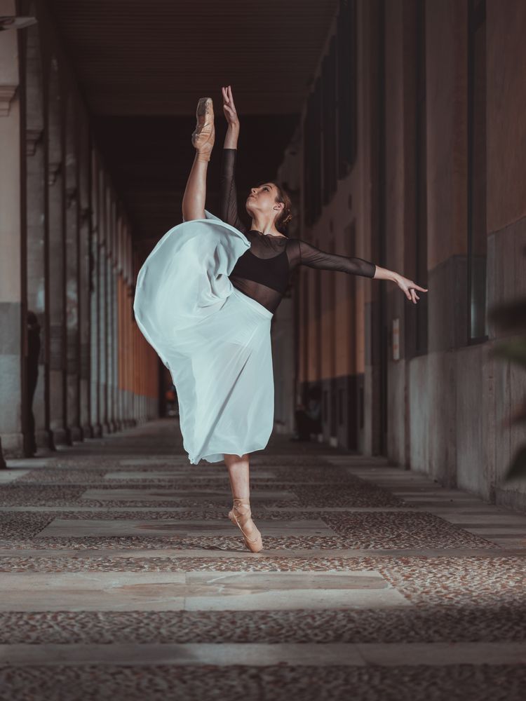 Graceful ballerina in pointe shoes standing in vertical split