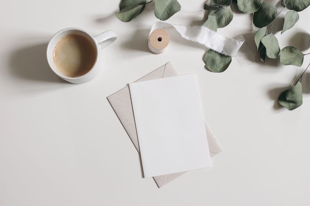 Dry eucalyptus tree leaves, branches and silk ribbon isolated on table with mock up card