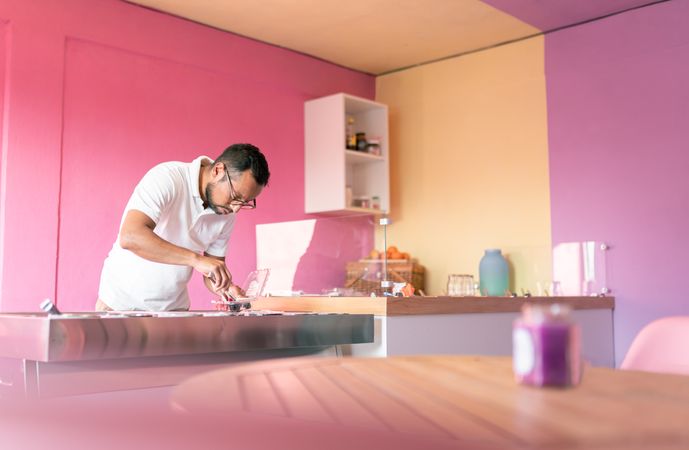 An ice-cream parlor worker is preparing some raspberry and blackberries on the roll machine