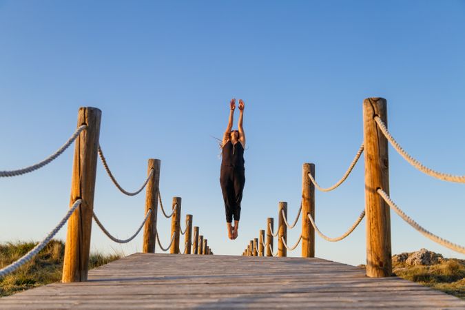 Woman posing in air on footbridge