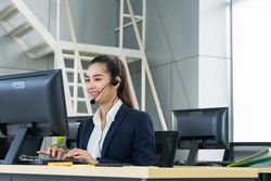 Woman speaking on headphones in call center