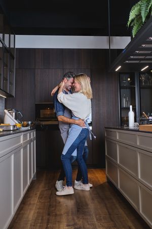 Couple in love embracing and dancing in kitchen