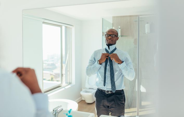 Businessman wearing a tie looking at the mirror
