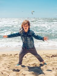 Cheerful boy on see sandy beach