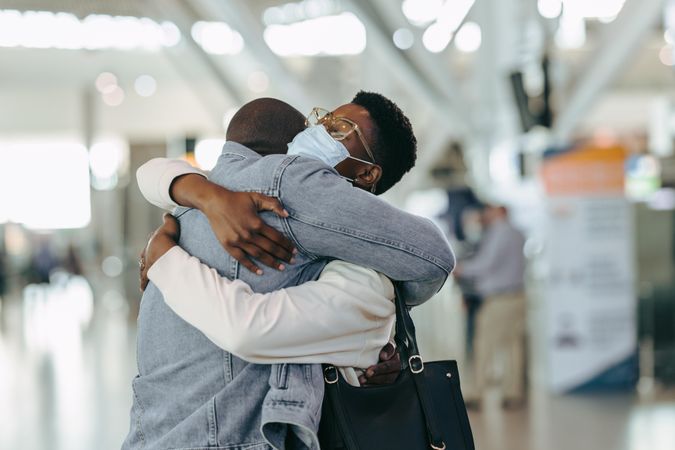 Black traveler couple during pandemic meeting at airport