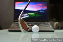 Golf club and ball in front of a laptop 0vVGL0