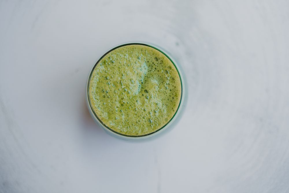 Delicious green smoothie with frothy in glass