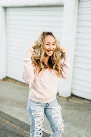 Smiling woman in pink sweater standing outdoor