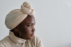 Thoughtful Black lady in ethnic headwear looking away
