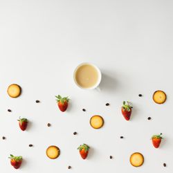 Coffee cup with cookie and strawberry pattern on light background