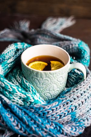 Teal scarf wrapped around cosy cup of tea