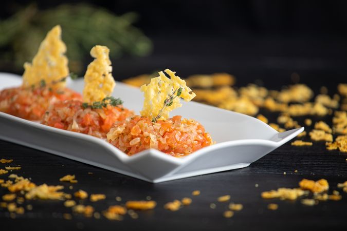 Tasty Quenelles of tomato fondue and Parmensan tile in ornamental plate