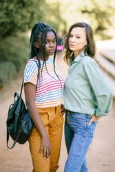 Two serious women in casual clothing posing in park walk way