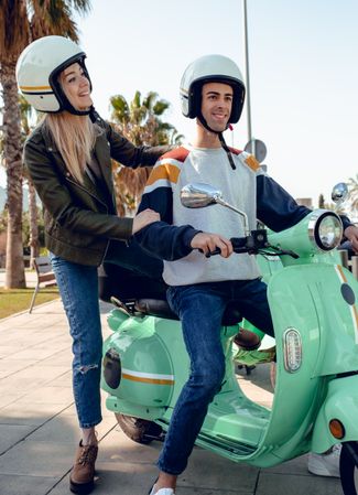 Couple getting on scooter
