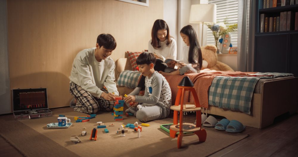 Successful Korean Parents Playing with Kids in Children's Room.