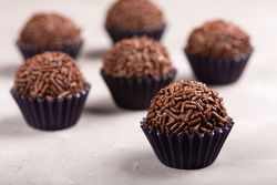 Close up of chocolate truffles with sprinkles on marble surface