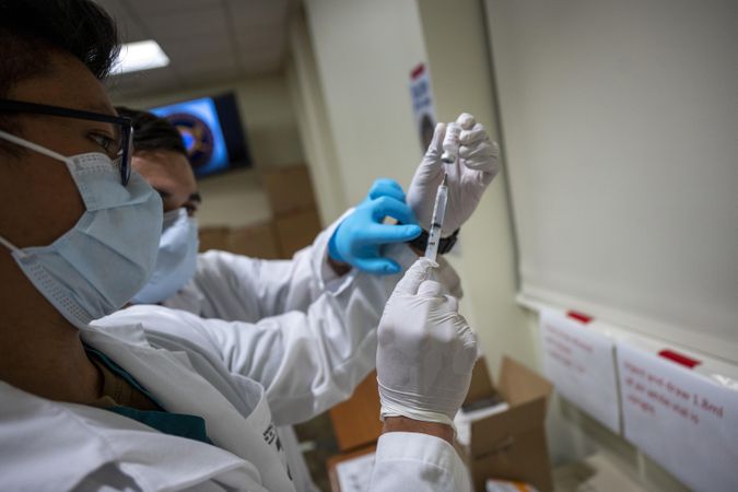 Bethesda, MD, USA - Dec. 14, 2020: Navy Hospitalman  prepare a dose of COVID vaccine